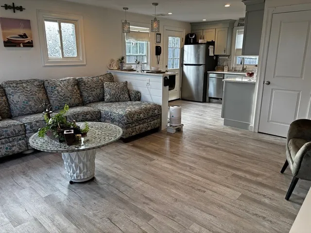 a living room with furniture and a refrigerator