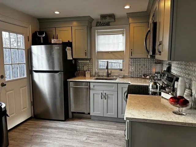 a kitchen with a refrigerator sink and white cabinets