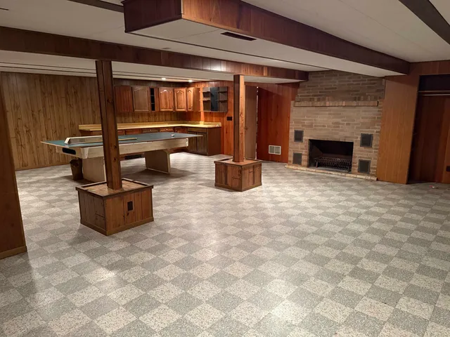 a room with pool table and two mirrors