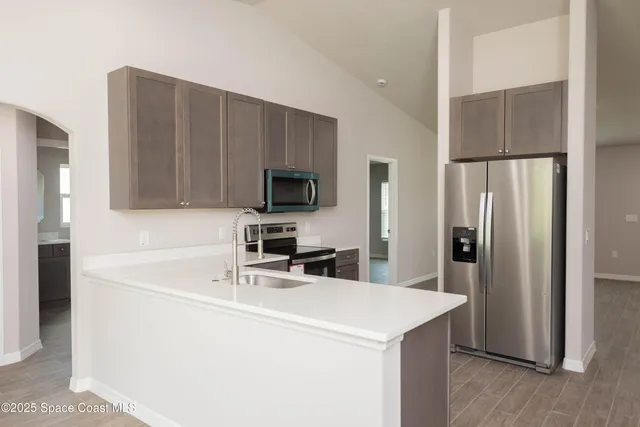 a kitchen with a sink a microwave a refrigerator and cabinets