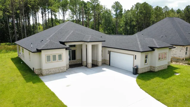 a aerial view of a house with a yard and large tree