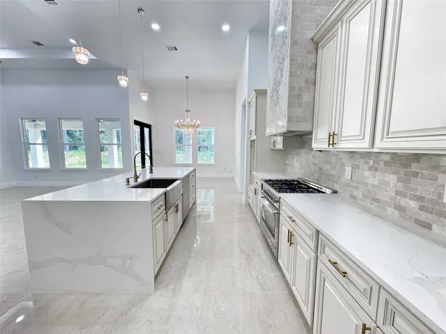 a large kitchen with stainless steel appliances granite countertop a lot of counter space and wooden floors