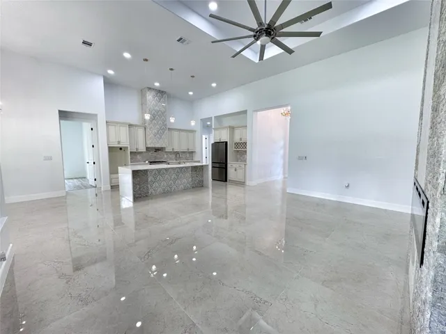 a view of kitchen with kitchen island a refrigerator sink and cabinets