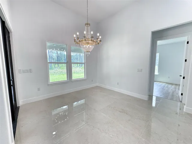 a view of a livingroom with a chandelier curtains and large windows
