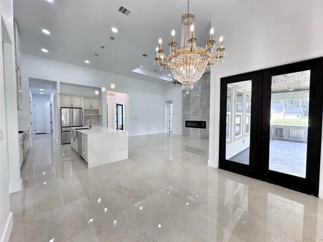 a view of a big room with chandelier and kitchen view