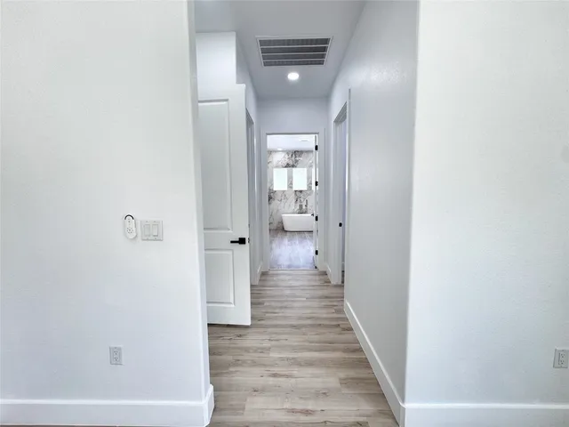 a view of a hallway with wooden floor