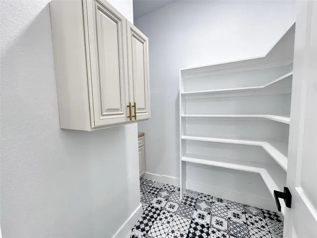 a walk in closet with wooden floor