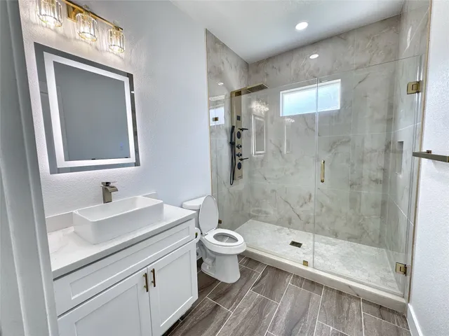 a bathroom with a sink a toilet and shower