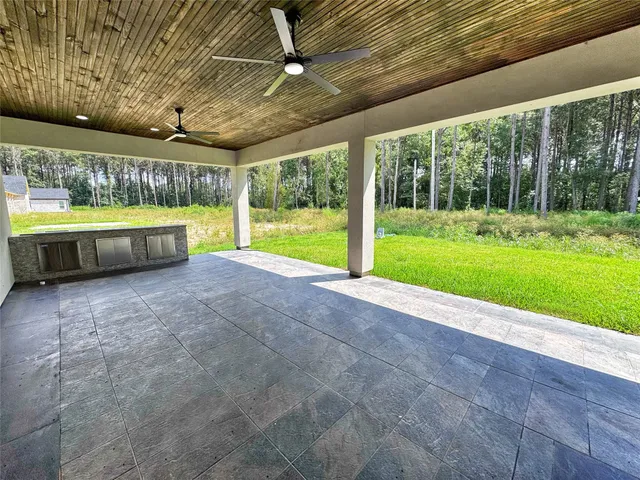 a view of a backyard with swimming pool and large trees
