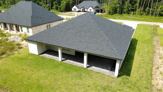 an aerial view of a house with swimming pool and yard