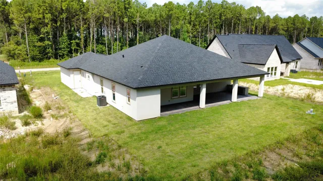 a aerial view of a house with swimming pool next to a yard