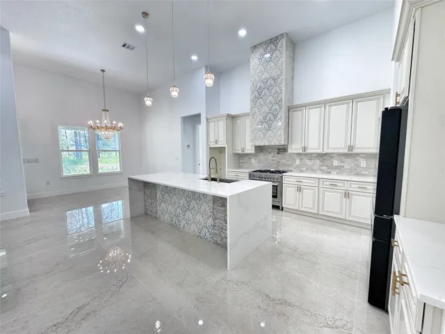 a large kitchen with kitchen island white cabinets and stainless steel appliances