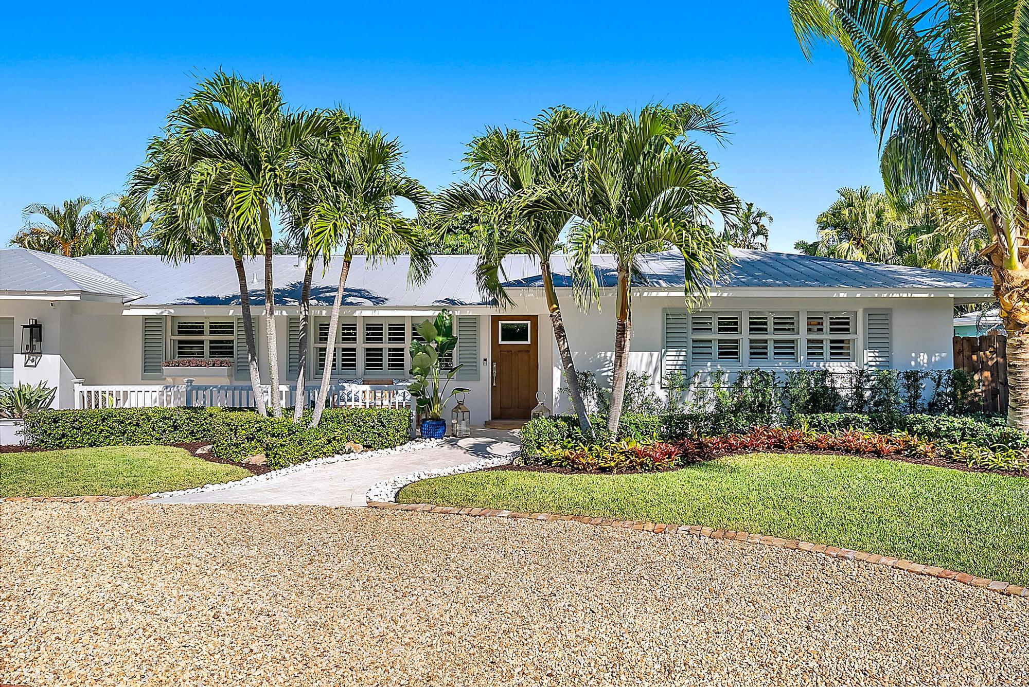 front view of a house with a yard and potted plants