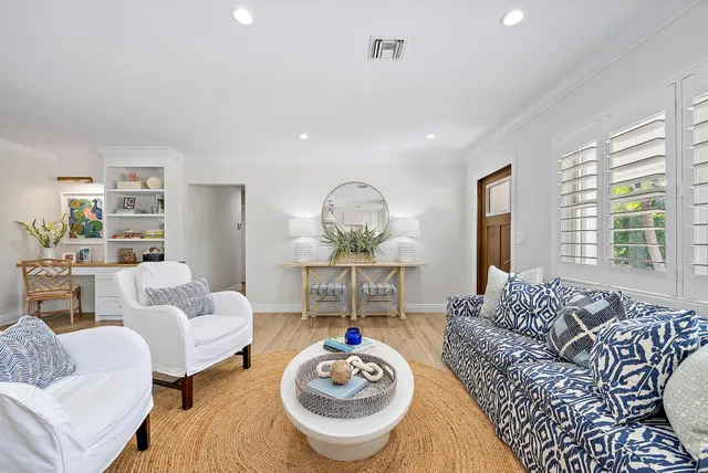 a living room with furniture a table and a large window