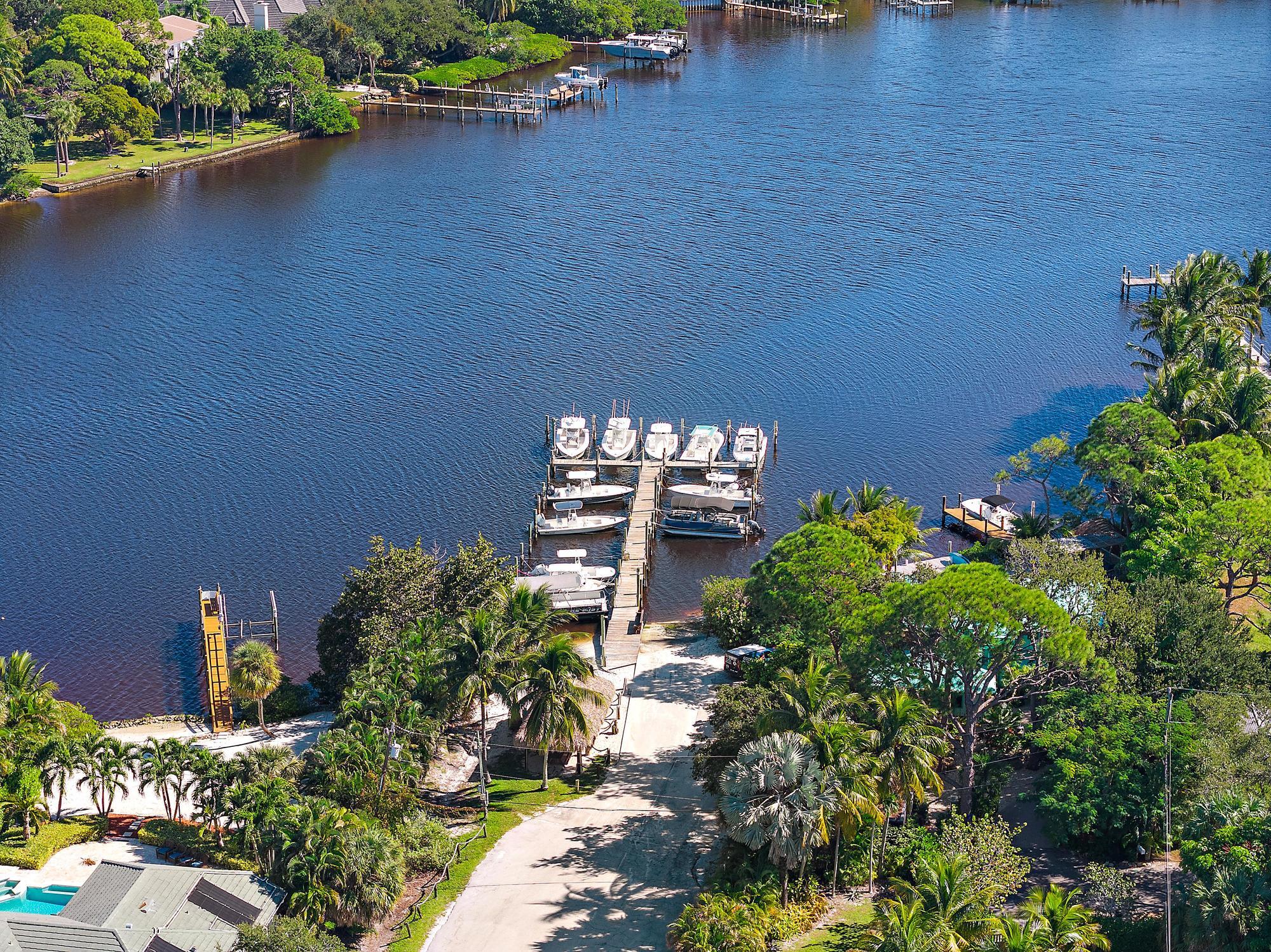 4967 Bimini Road Tequesta, FL 33469 - Photo 36 of 36 a backyard of a house with lots of green space and a lake view