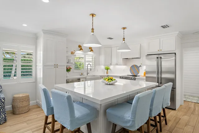 a view of a dining room and livingroom with furniture wooden floor a chandelier