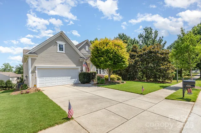 a front view of a house with a yard and trees