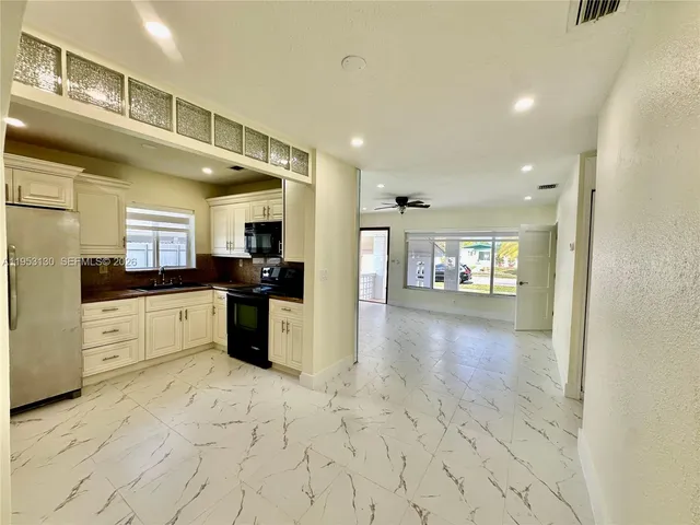 a large white kitchen with a stove a sink and a refrigerator