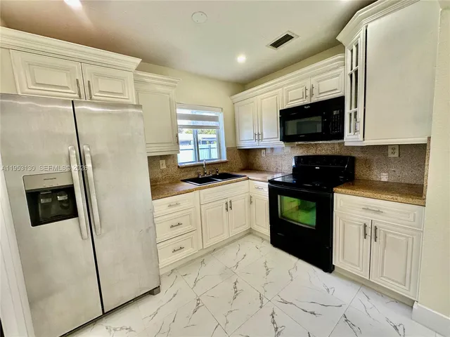 a kitchen with stainless steel appliances a refrigerator sink and microwave