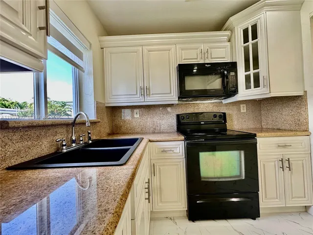 a kitchen with a sink and a stove top oven