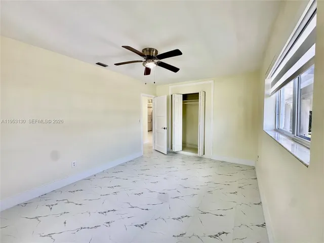 a view of empty room with wooden floor