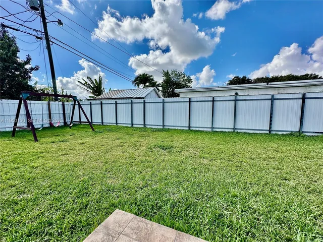 a view of a house with a backyard and a slide