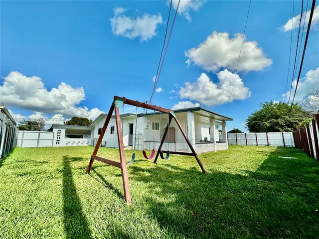 a view of a house with backyard and a garden