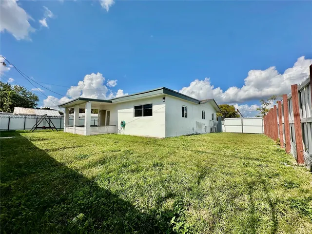 a view of a house with backyard and sitting area