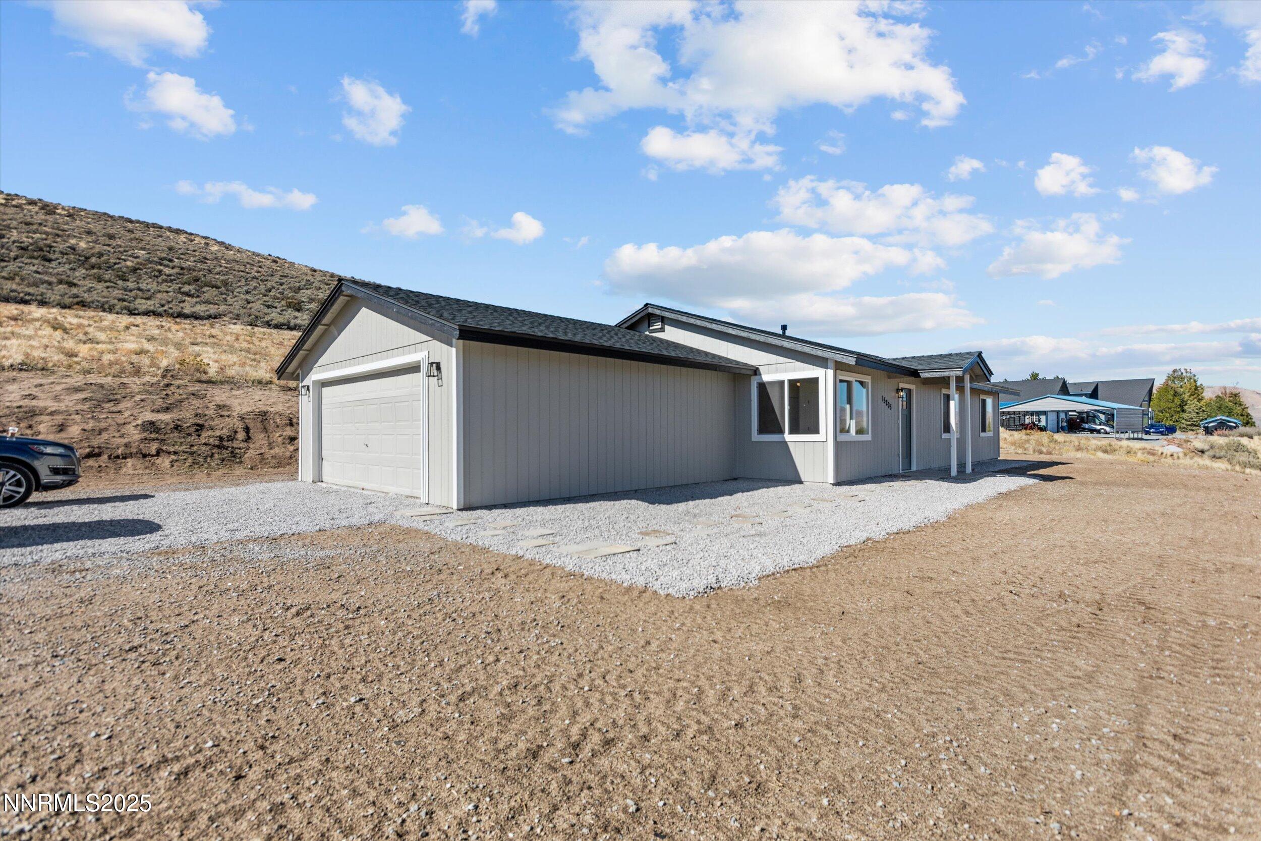 15205 North Red Rock Road Reno, NV 89508 - Photo 2 of 23 a front view of a house with a yard and garage