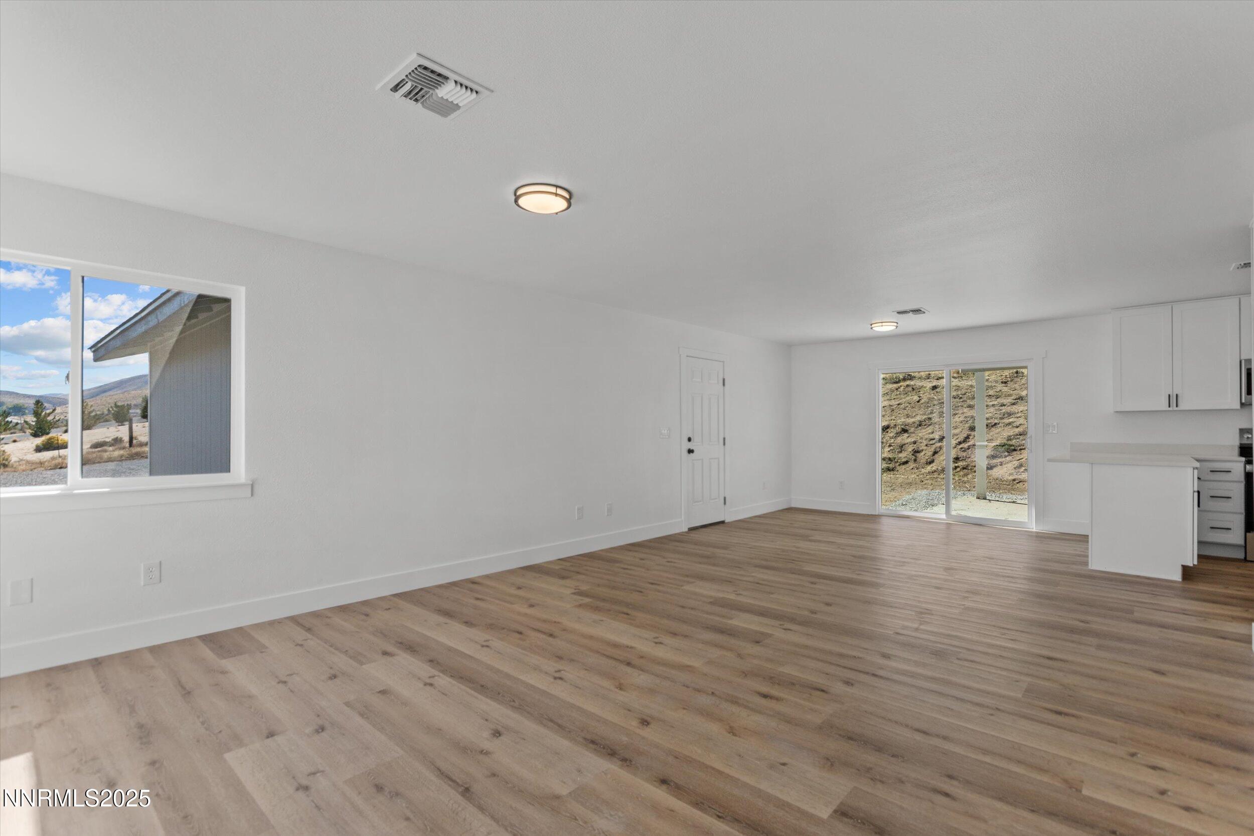15205 North Red Rock Road Reno, NV 89508 - Photo 4 of 23 an empty room with wooden floor and windows