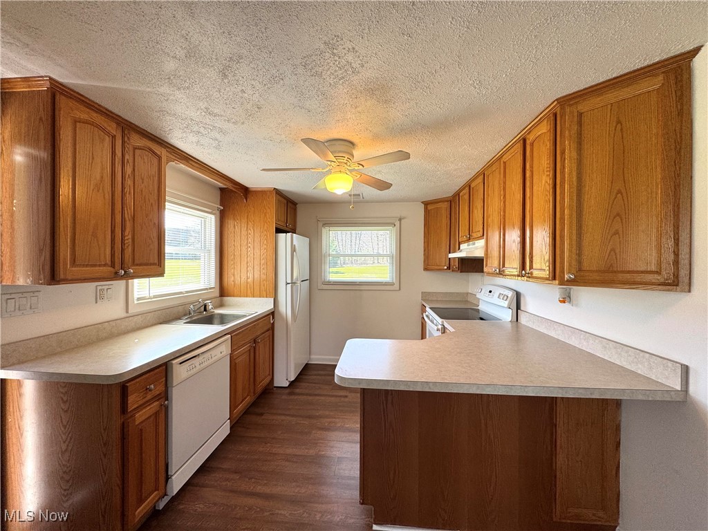 8961 Herbert Road Canfield, OH 44406 - Photo 7 of 26 Kitchen with brown cabinetry, white appliances, and a sink