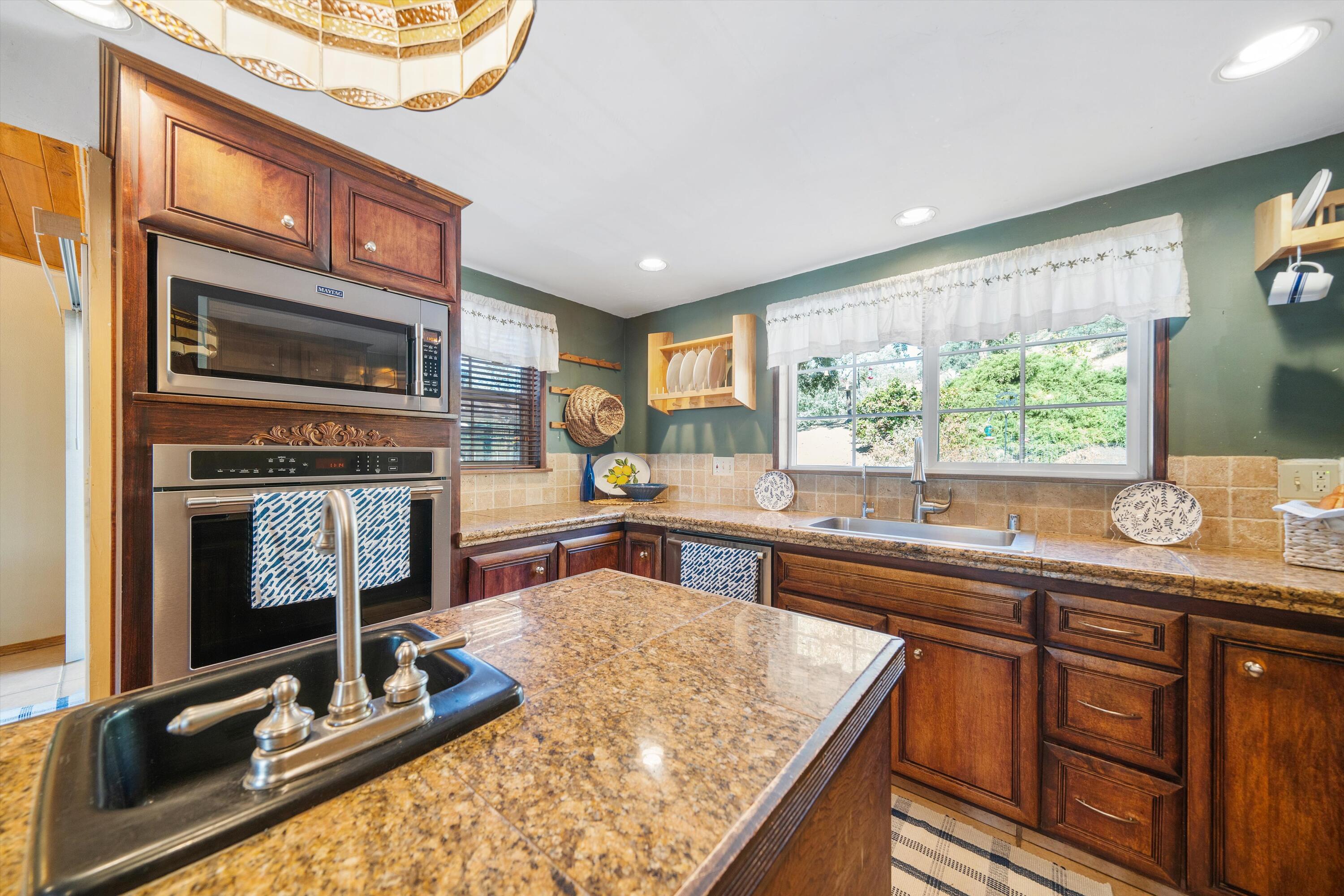 25801 Cumberland Road Tehachapi, CA 93561 - Photo 11 of 35 a kitchen with sink stove and cabinets