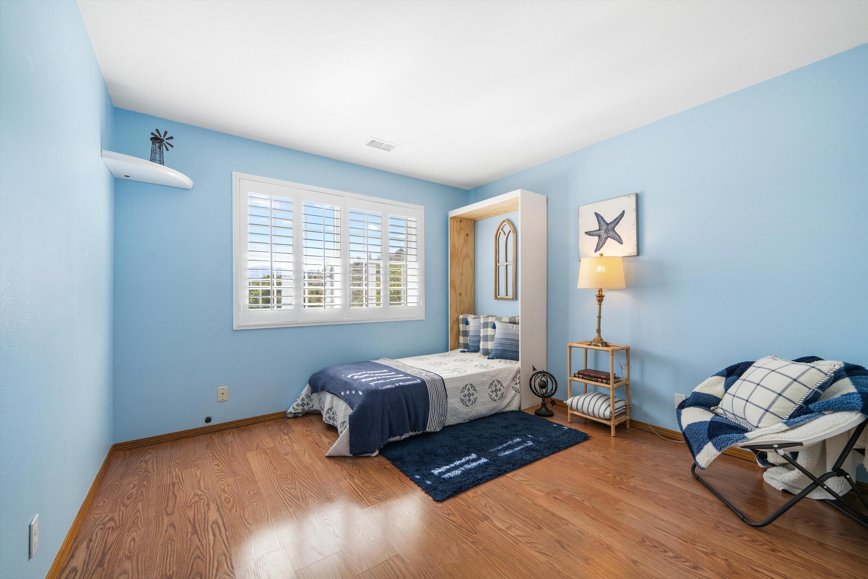 25801 Cumberland Road Tehachapi, CA 93561 - Photo 18 of 35 a bedroom with a bed and wooden floor