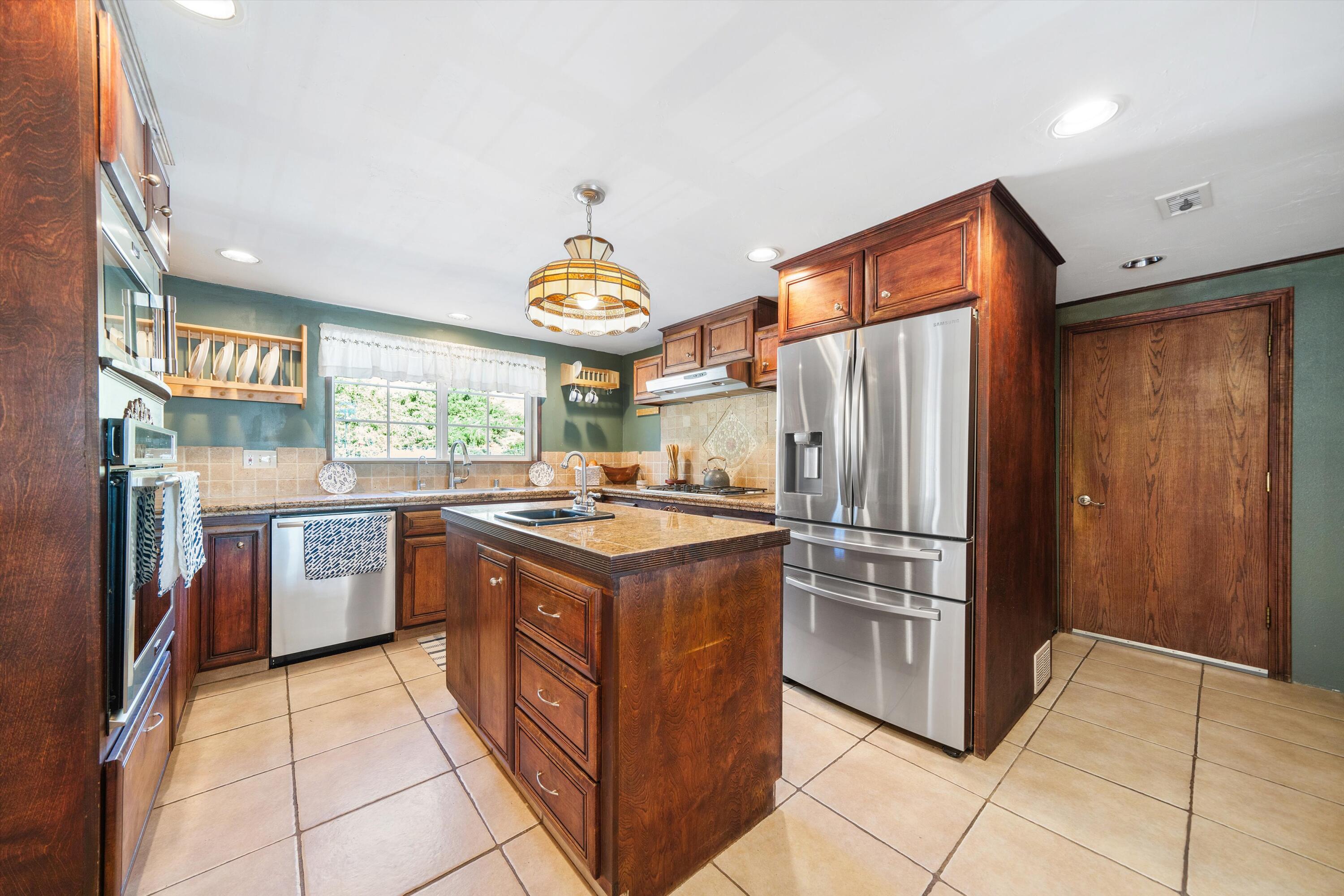 25801 Cumberland Road Tehachapi, CA 93561 - Photo 10 of 35 a kitchen with stainless steel appliances granite countertop a stove and a refrigerator