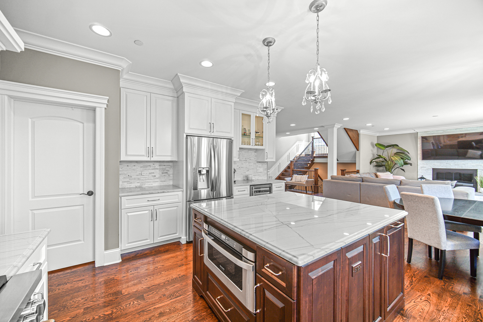 915 Forestview Road Addison, IL 60101 - Photo 14 of 49 a kitchen that has a center island white cabinetry and a wooden floor