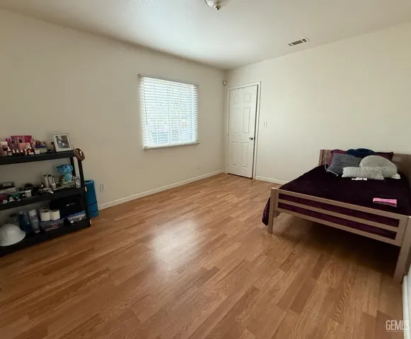 a bedroom with a bed and wooden floor