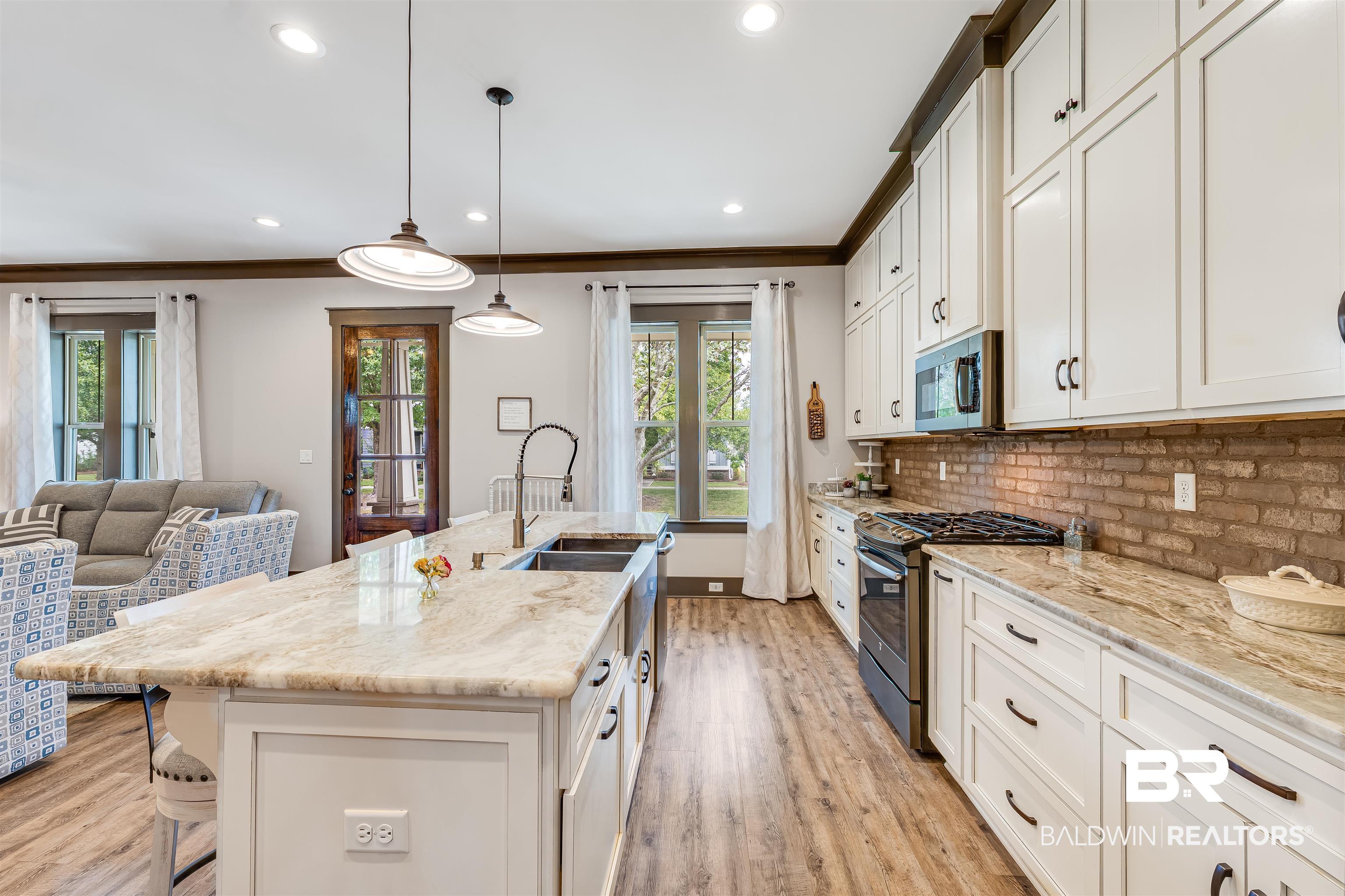 1119 Pink Poppy Lane Foley, AL 36535 - Photo 23 of 38 Kitchen featuring white cabinetry, a breakfast bar area, stainless steel appliances, crown molding, and recessed lighting