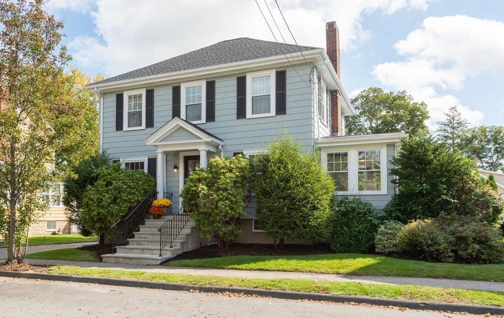 a front view of a house with a yard and trees