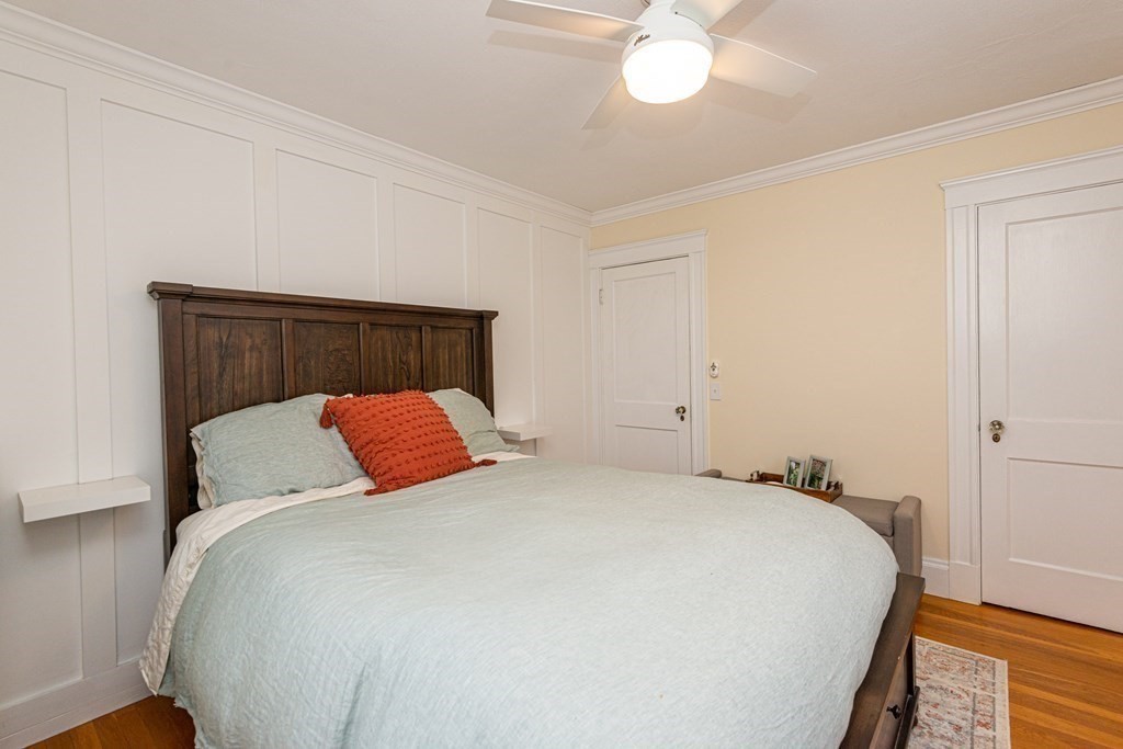 23 Trask Street Danvers, MA 01923 - Photo 26 of 42 a bed sitting in a bedroom next to a window and a chandelier