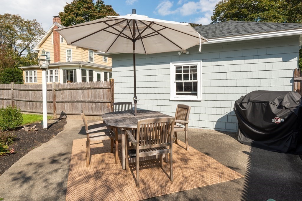23 Trask Street Danvers, MA 01923 - Photo 41 of 42 a patio with a table and chairs under an umbrella