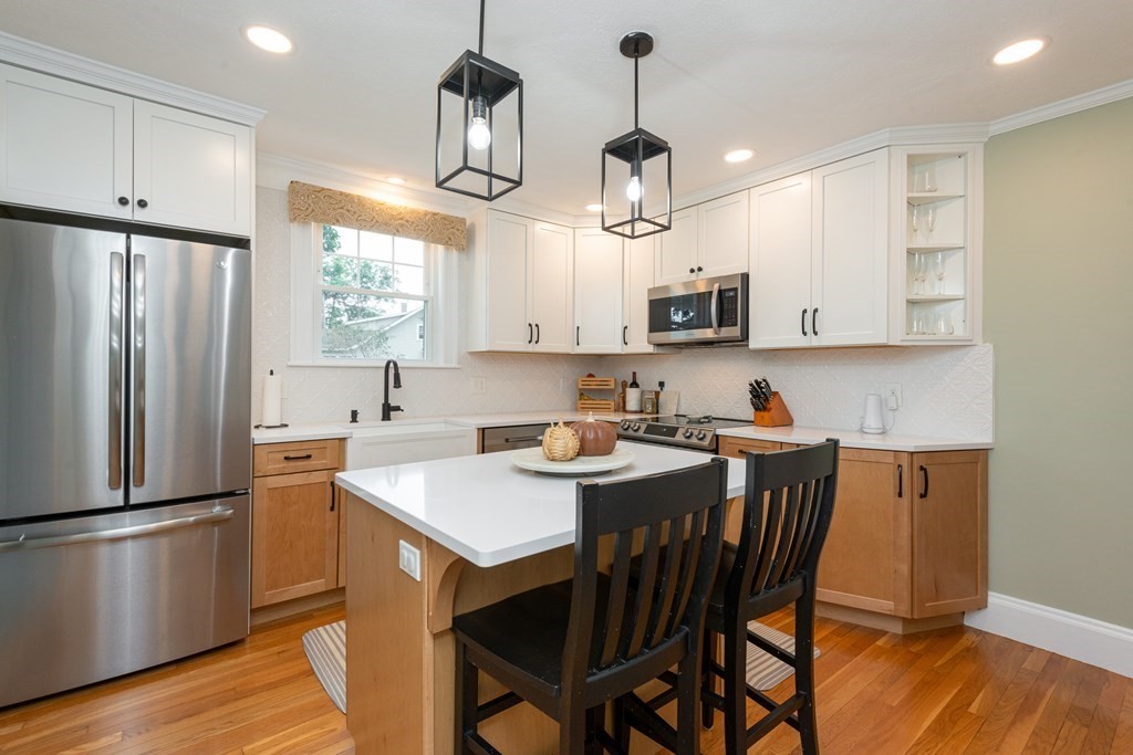 23 Trask Street Danvers, MA 01923 - Photo 7 of 42 a kitchen with stainless steel appliances granite countertop a sink a microwave refrigerator and a stove