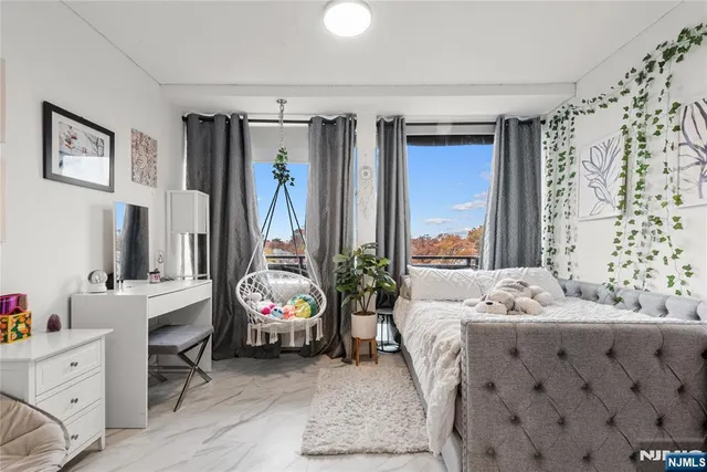 a bedroom with a bed and a large mirror next to a window