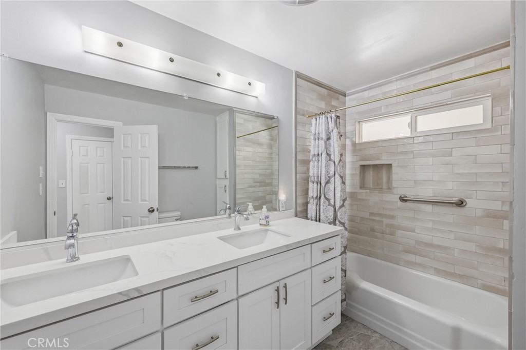 24673 Barton Road Loma Linda, CA 92354 - Photo 21 of 38 a bathroom with a sink double vanity granite tub shower and a mirror