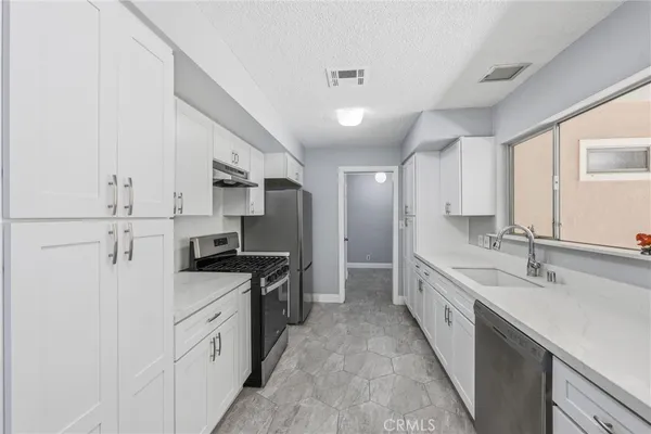 a kitchen with stainless steel appliances a refrigerator sink and stove
