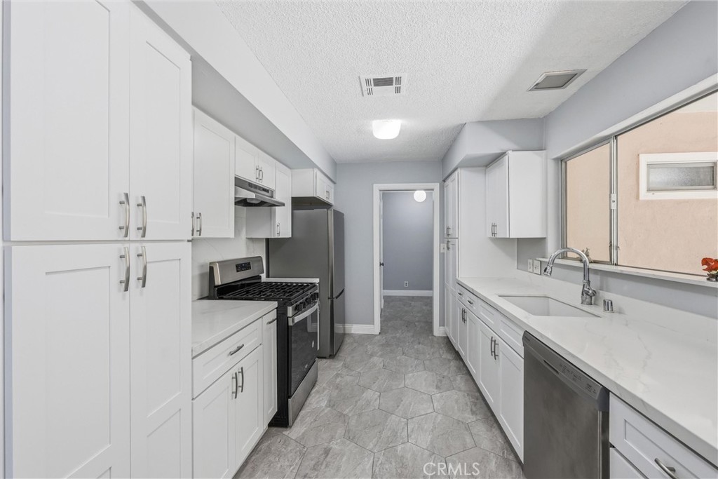 24673 Barton Road Loma Linda, CA 92354 - Photo 7 of 38 a kitchen with stainless steel appliances granite countertop a sink stove and refrigerator