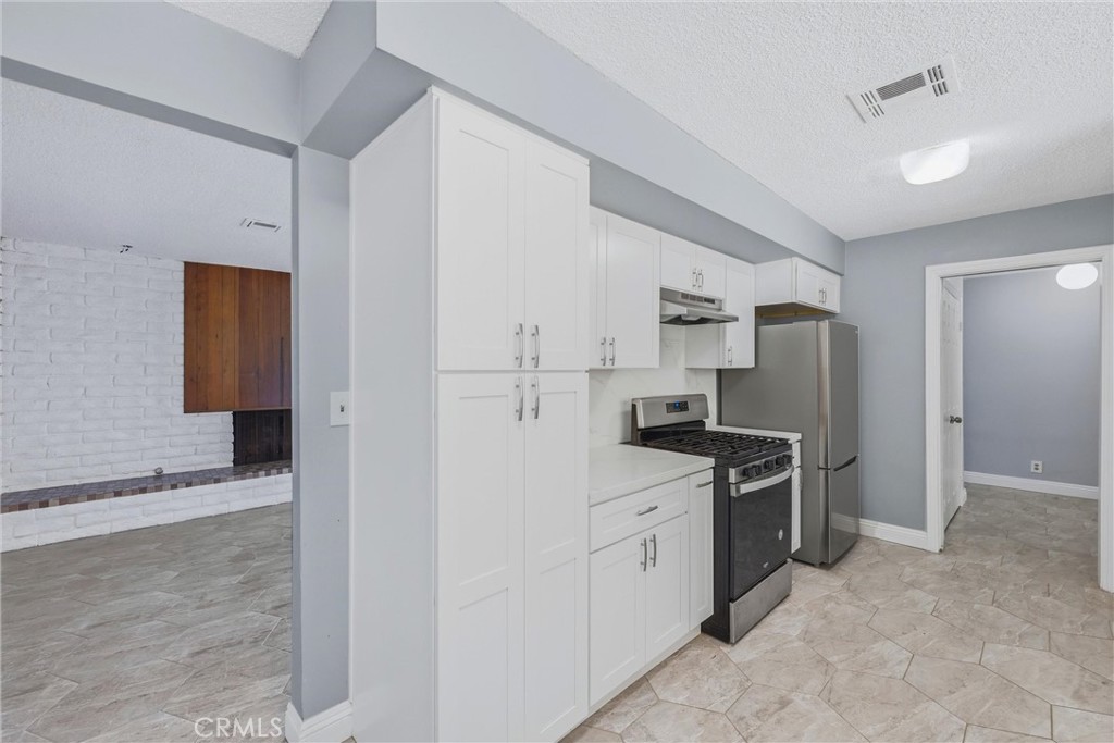 24673 Barton Road Loma Linda, CA 92354 - Photo 9 of 38 a kitchen with stainless steel appliances a refrigerator sink and stove