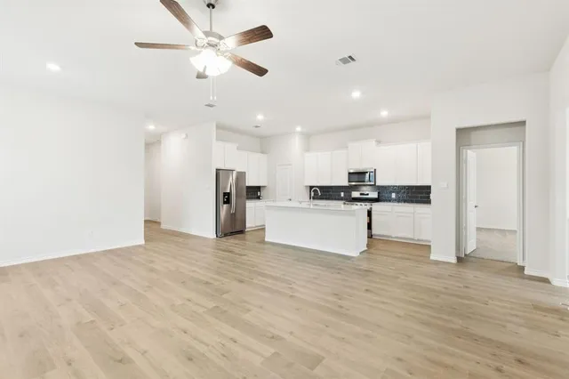 a view of kitchen with refrigerator sink and cabinets