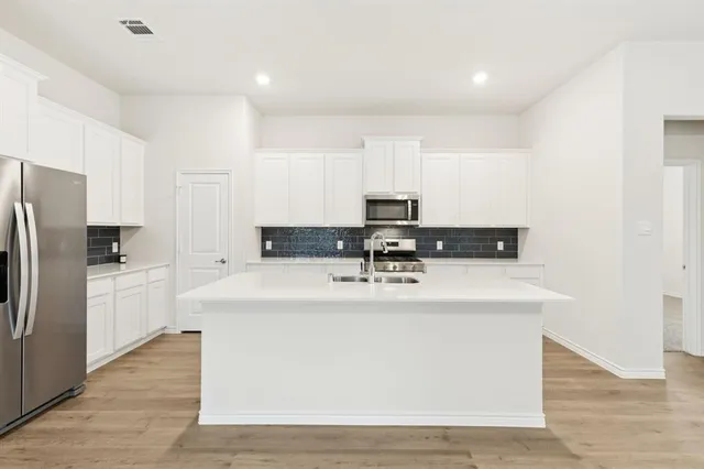 a view of kitchen with stainless steel appliances granite countertop a refrigerator a sink and a stove