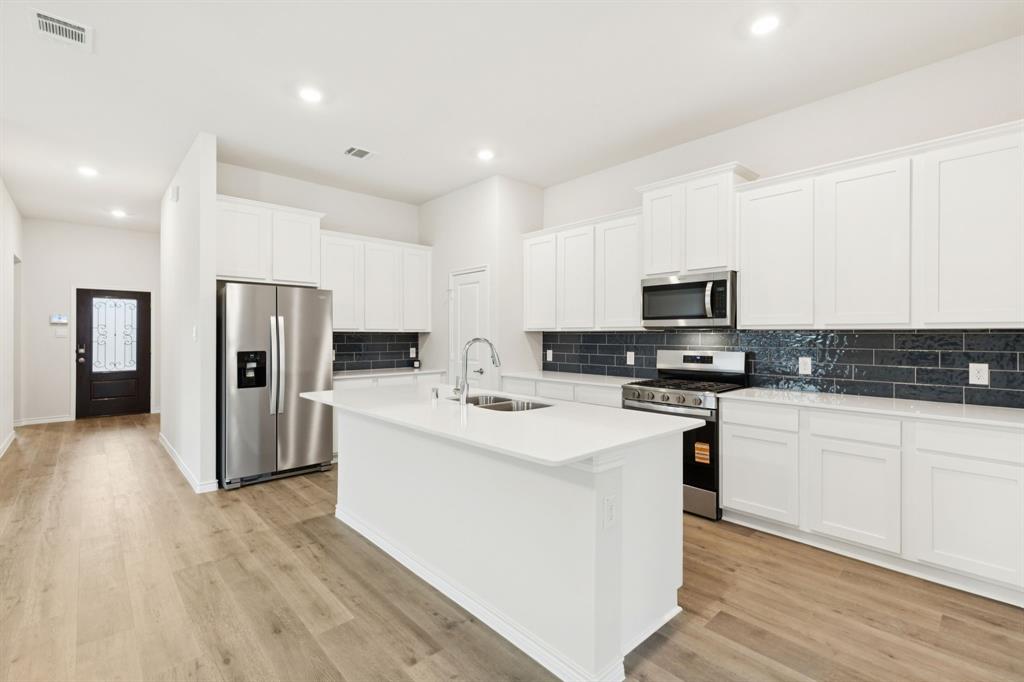2209 Tacoma Way Anna, TX 75409 - Photo 15 of 29 a kitchen with stainless steel appliances a refrigerator stove microwave and sink