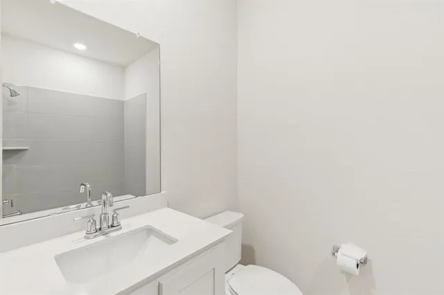 a bathroom with a sink mirror and toilet